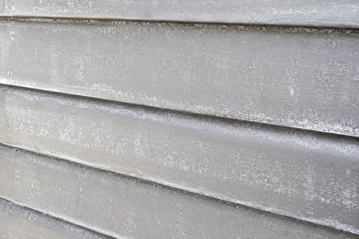 Can You Paint Aluminum Siding? Yes, Here's How It's Done 1 Close-up of heavily oxidized aluminum siding showing white chalky residue and dull surface