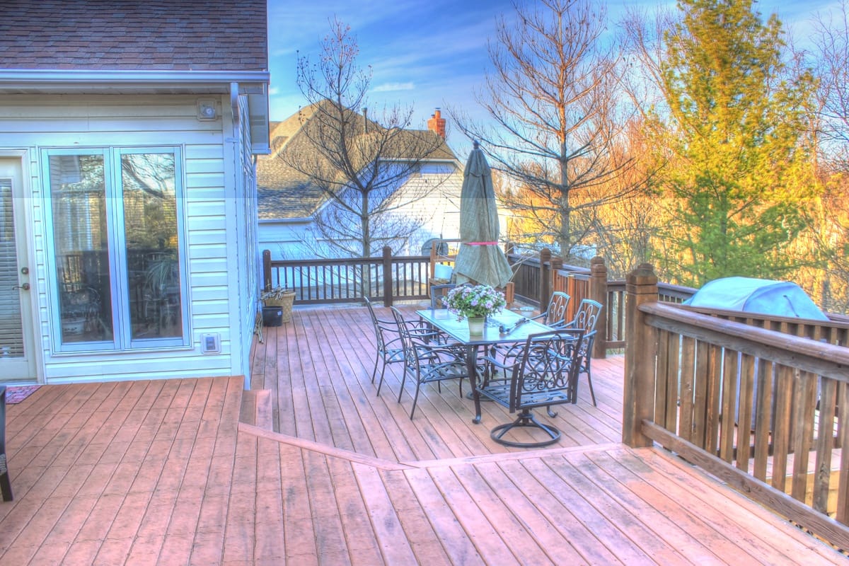 Finished deck with warm brown stain complementing house exterior and surrounding landscape